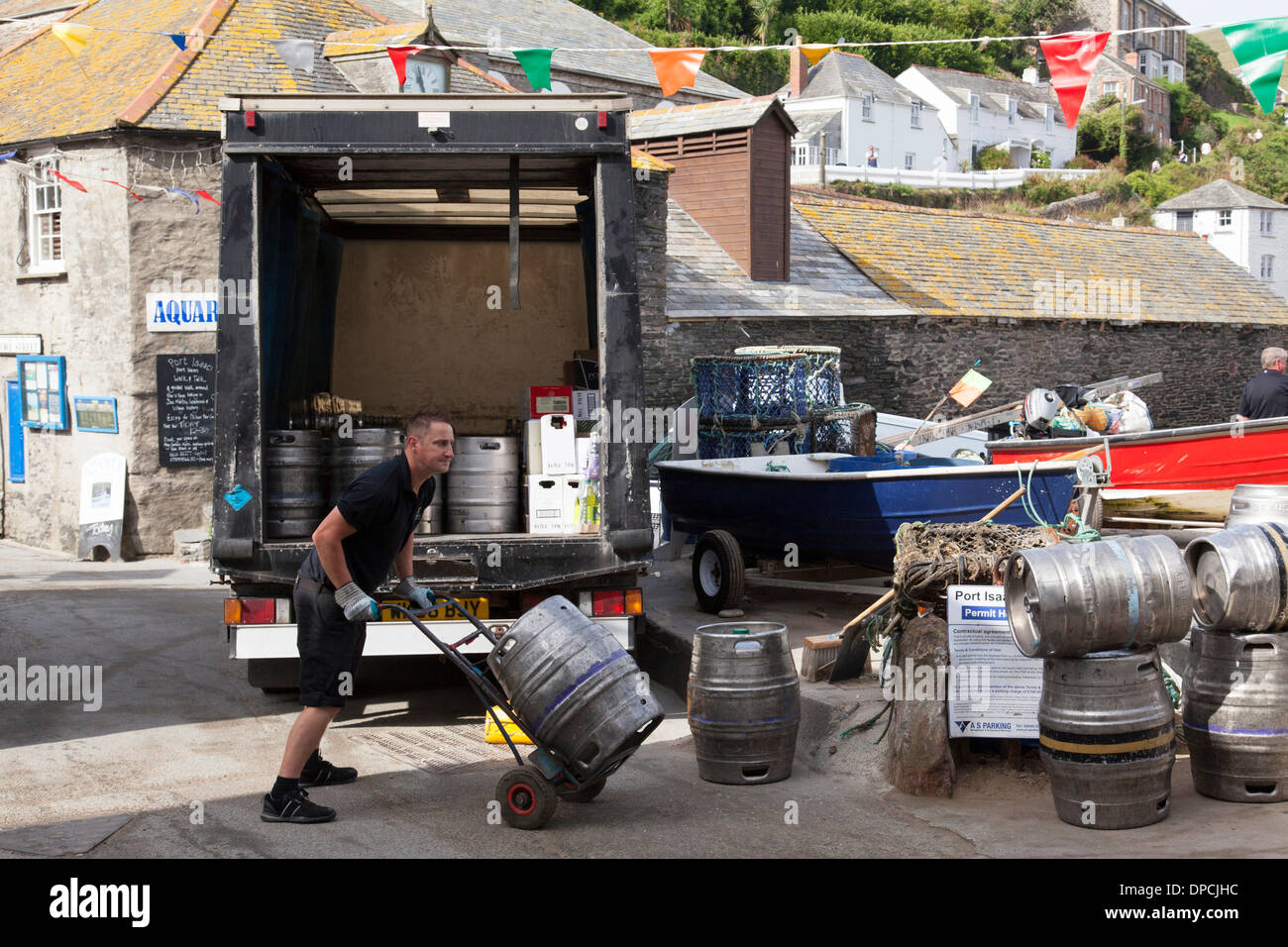 A brewery drayman delivering beer kegs to a public house in Cornwall, U.K. Stock Photo