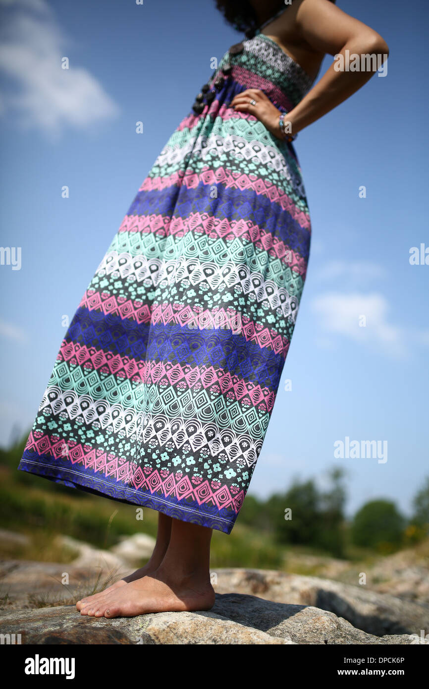 Young asian girl in a colorful maxi dress playing by a river in the summer Stock Photo