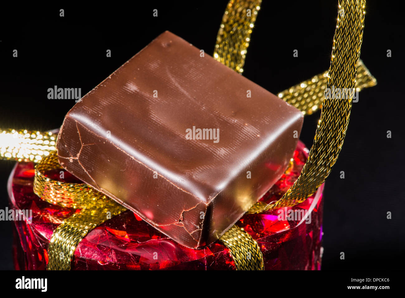 Chocolate bonbon and gold color shiny package Stock Photo