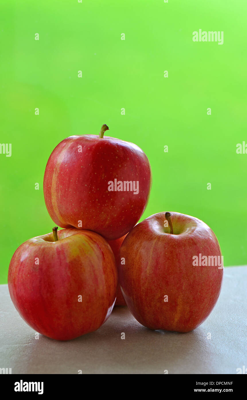 Delicious Gala apples on windowsill with vibrant green background Stock Photo