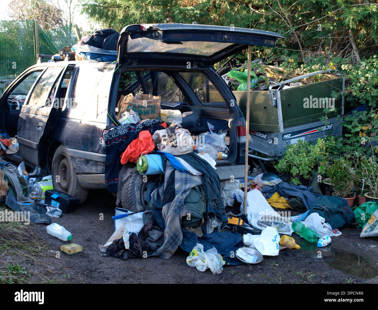 Rubbish spilling out of the back of an old car, Bude, Cornwall, UK Stock Photo