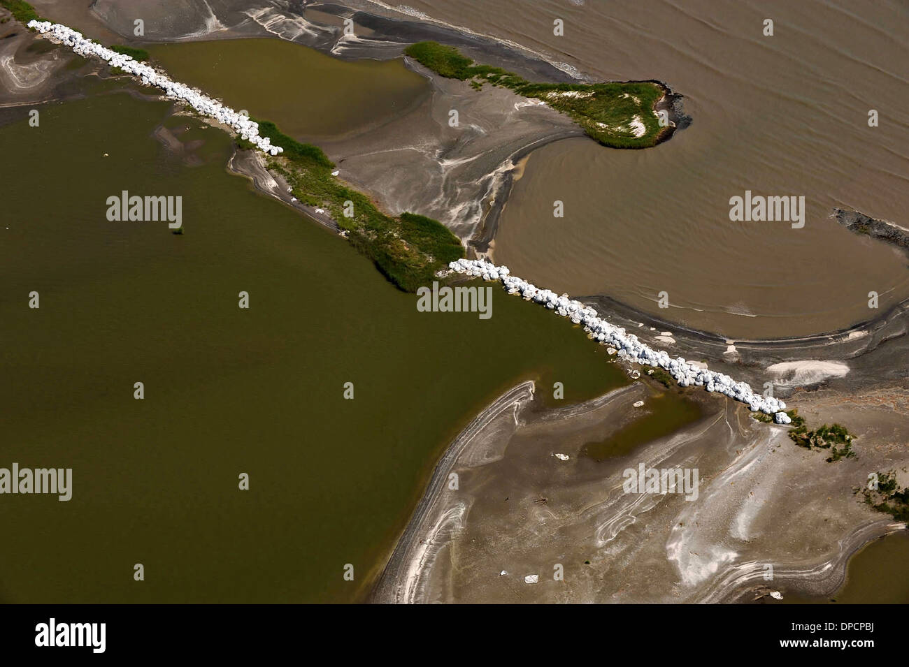 Aerial view of sandbag barriers to prevent crude oil leaking from the blowout of the BP Oil Deepwater Horizon from entering the marsh estuary July 30, 2010 in Grand Isle, Louisiana. Stock Photo