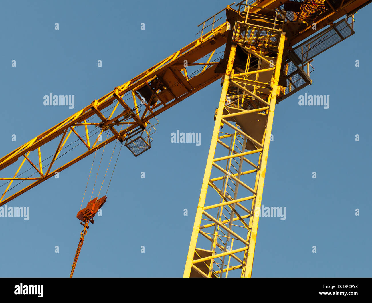 Yellow tower crane fragment above blue sky Stock Photo