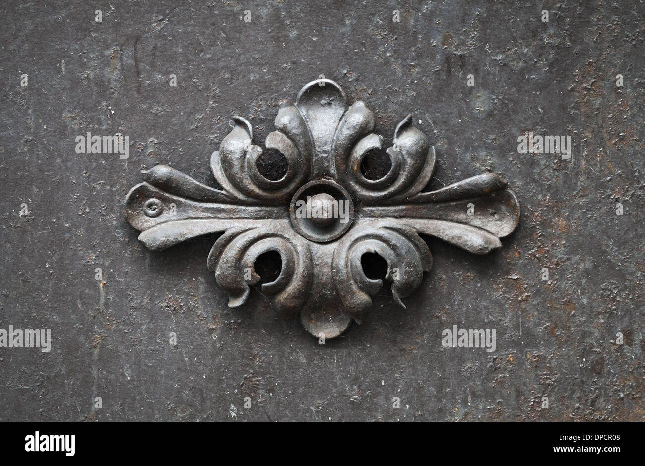 Ancient forged floral decoration element on black door Stock Photo