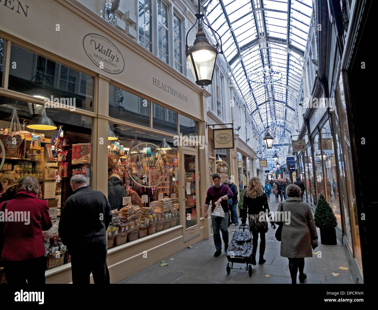 Shoppers walking past Wally's delicatessen in Royal Arcade  at Christmas time in Cardiff City Centre Wales UK KATHY DEWITT Stock Photo