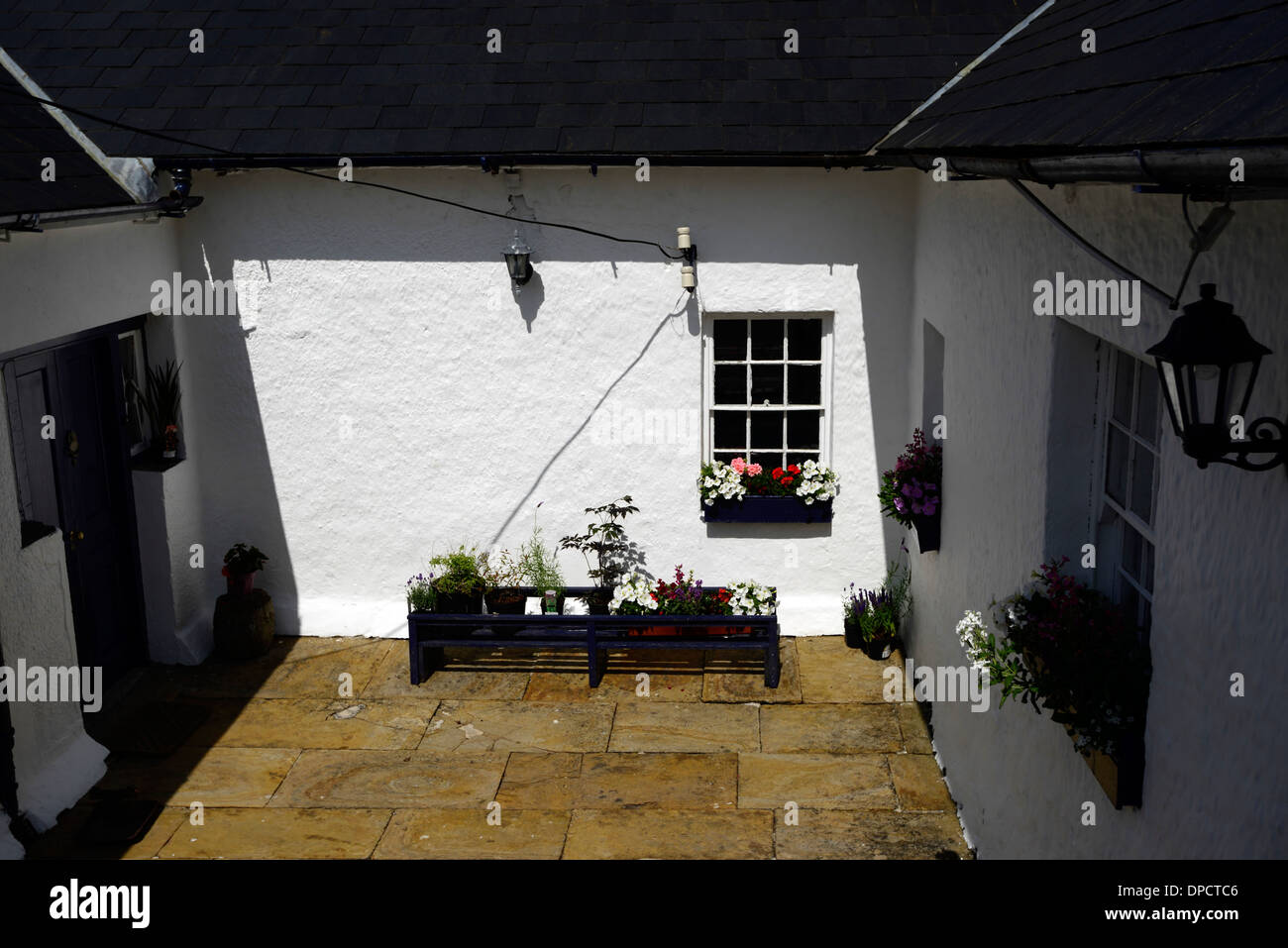 courtyard painted white walls sun trap sunny patio area Stock Photo
