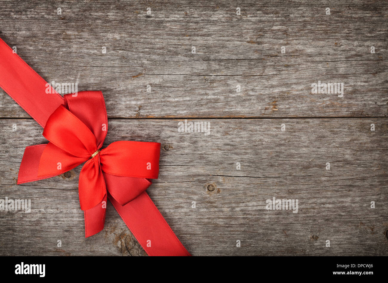 Wooden background with red bow and ribbon with copy space Stock Photo