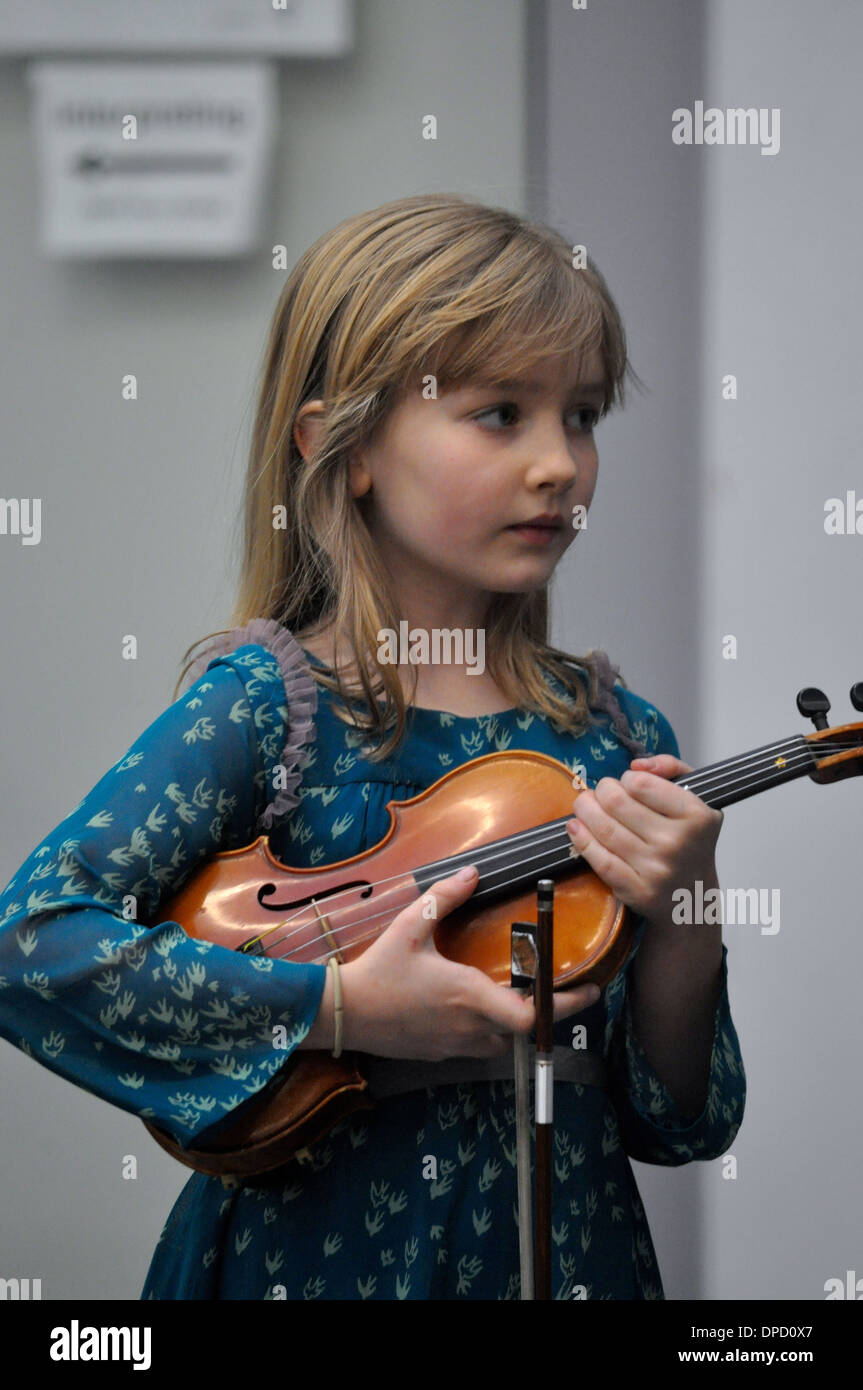 little blonde girl holding a violin under her arm Stock Photo