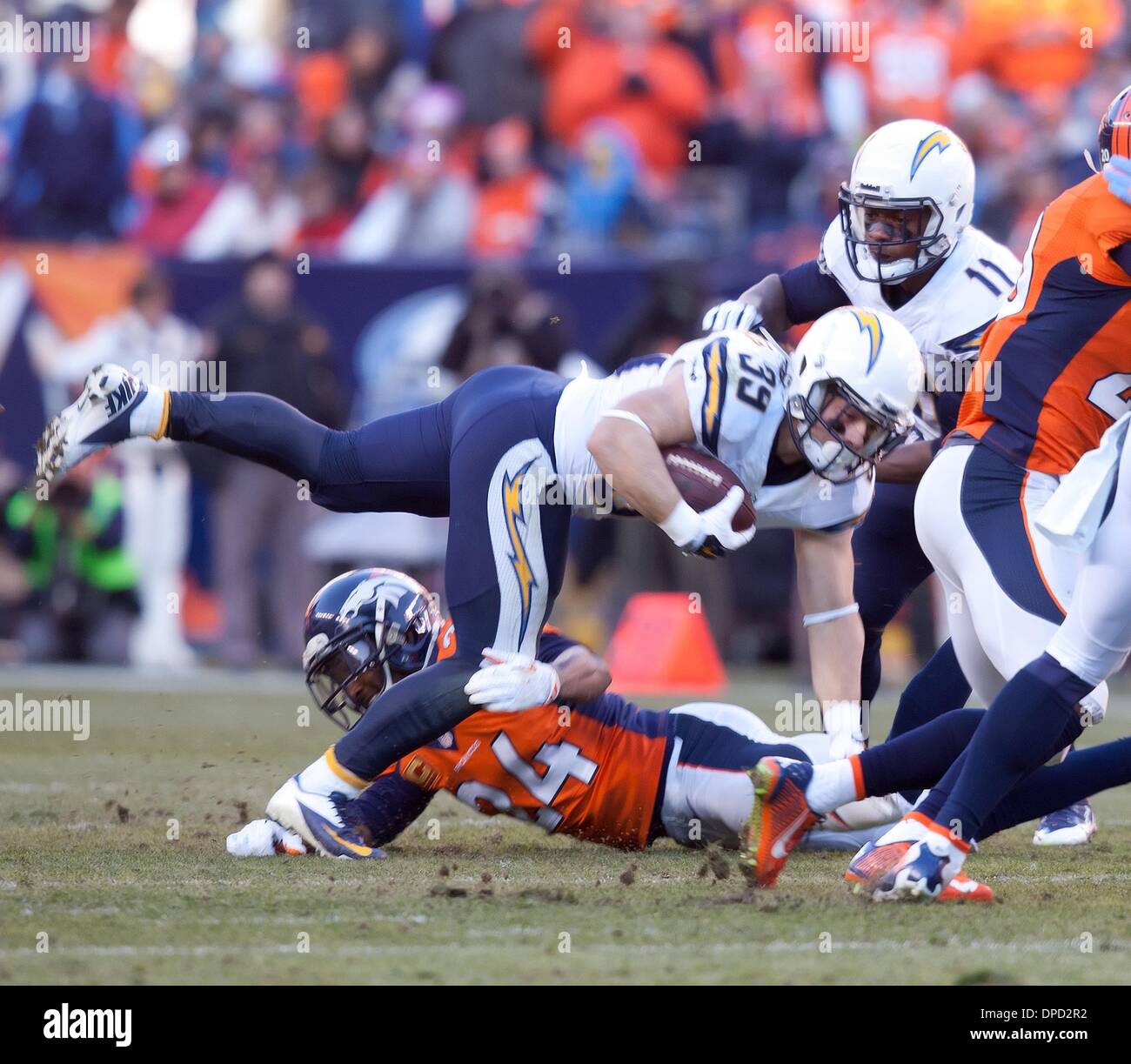 Denver, Colorado, USA. 12th Jan, 2014. Denver, Colorado, USA. 12th Jan, 2014. Chargers RB DANNY WOODHEAD, center, gets tackled by Broncos CB CHAMP BAILEY, bottom, during the 1st. half at Sports Authority Field at Mile High Sunday afternoon. The Broncos beat the Chargers 24-17. Credit:  Hector Acevedo/ZUMAPRESS.com/Alamy Live News Stock Photo
