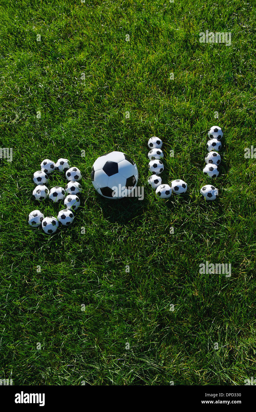 Brazilian soccer goal message spells out gol in footballs on green grass field Stock Photo