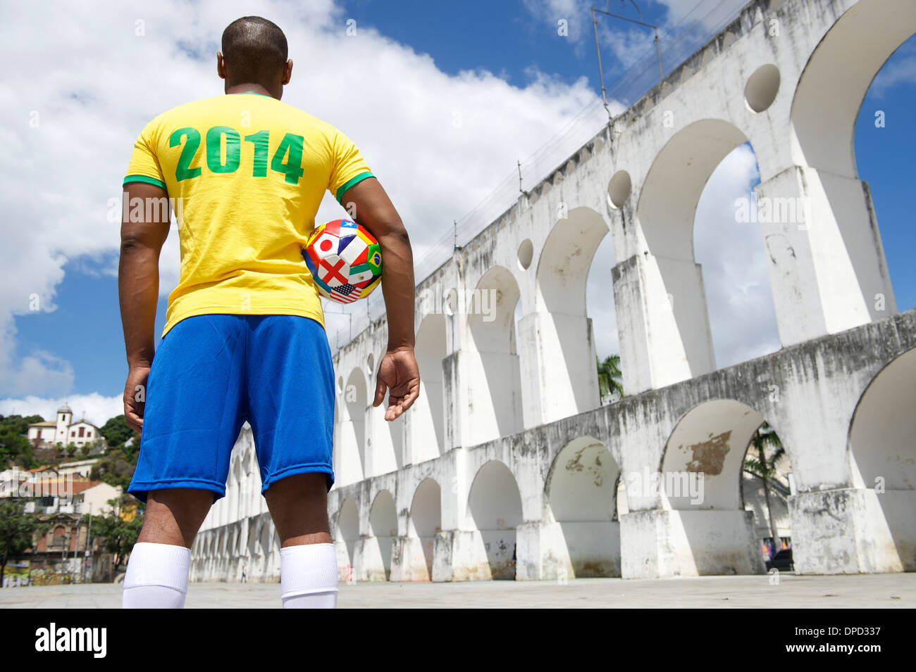 Brazilian soccer player holding international football wearing 2014 shirt in Brazil colors Rio de Janeiro Stock Photo