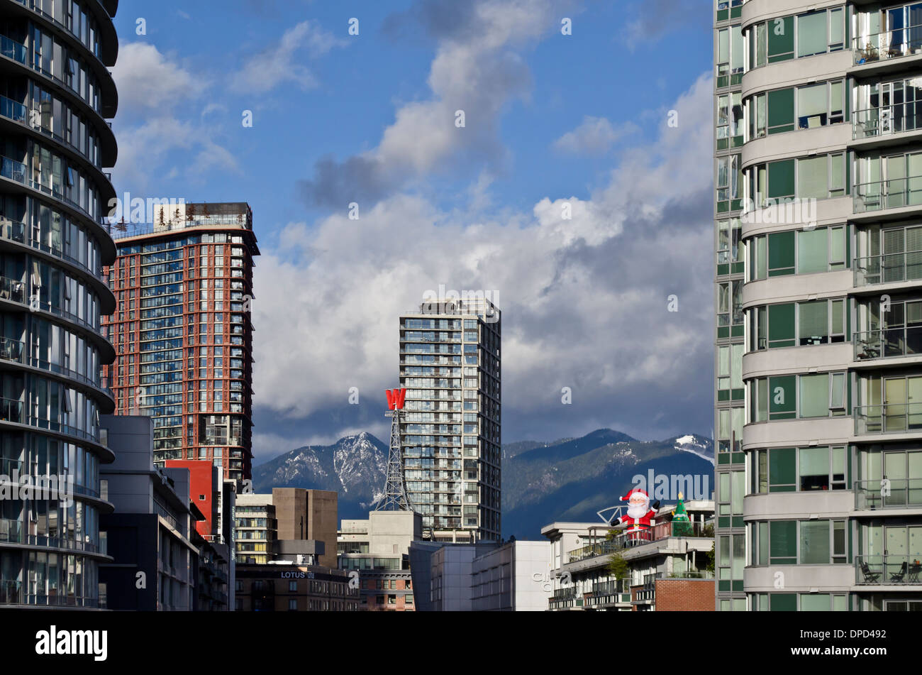 Highrise buildings of downtown Vancouver with the north shore mountains in the distance.  Christmas decorations displayed. Stock Photo