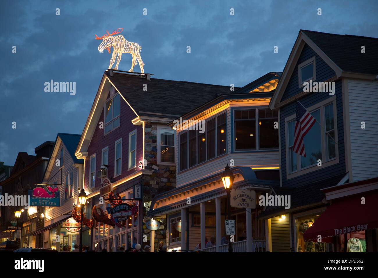 A large illuminated moose on the roof of shops in Bar Harbor, Maine USA - just outside of Acadia National Park Stock Photo