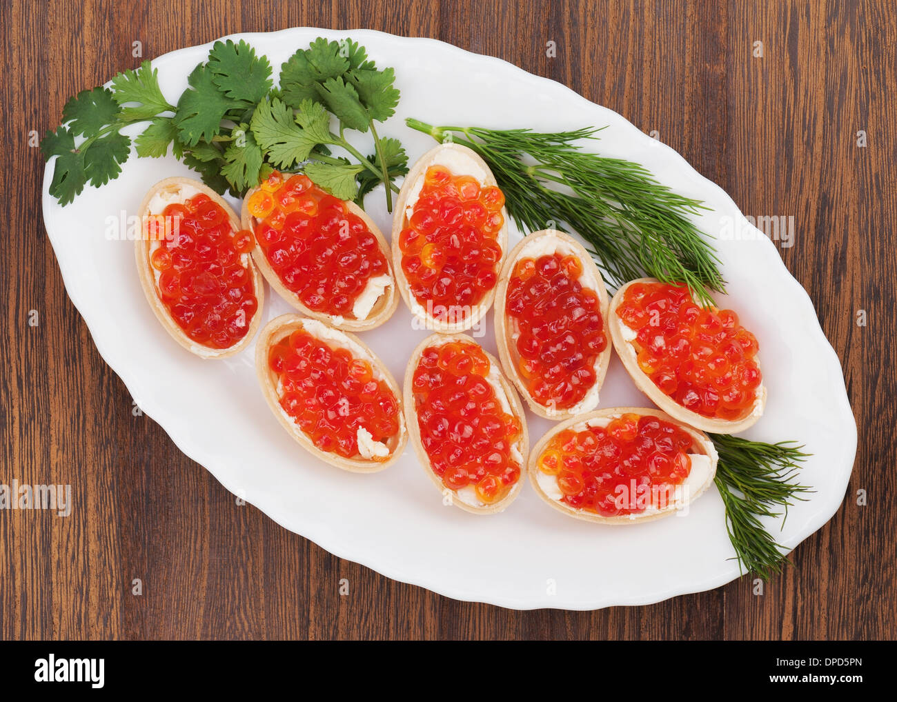 Tartlets with red caviar on wooden background. Closeup. Stock Photo