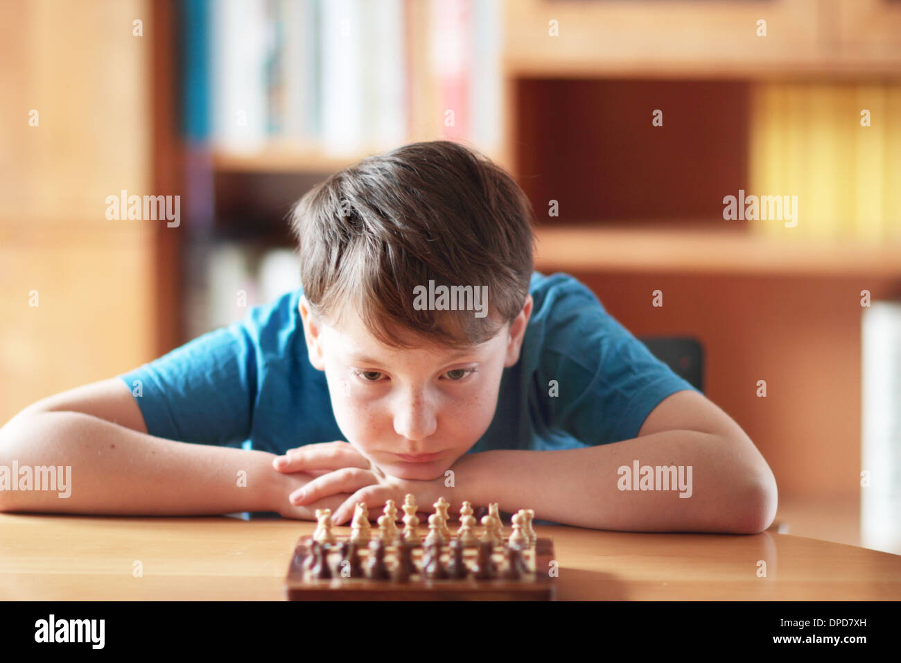 young boy playing ches at home on a table Stock Photo