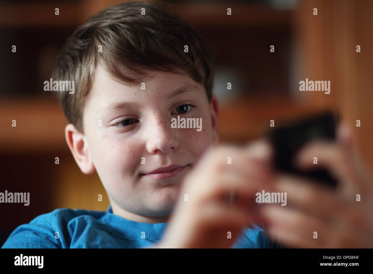 young boy watching to a mobile phone at home Stock Photo - Alamy