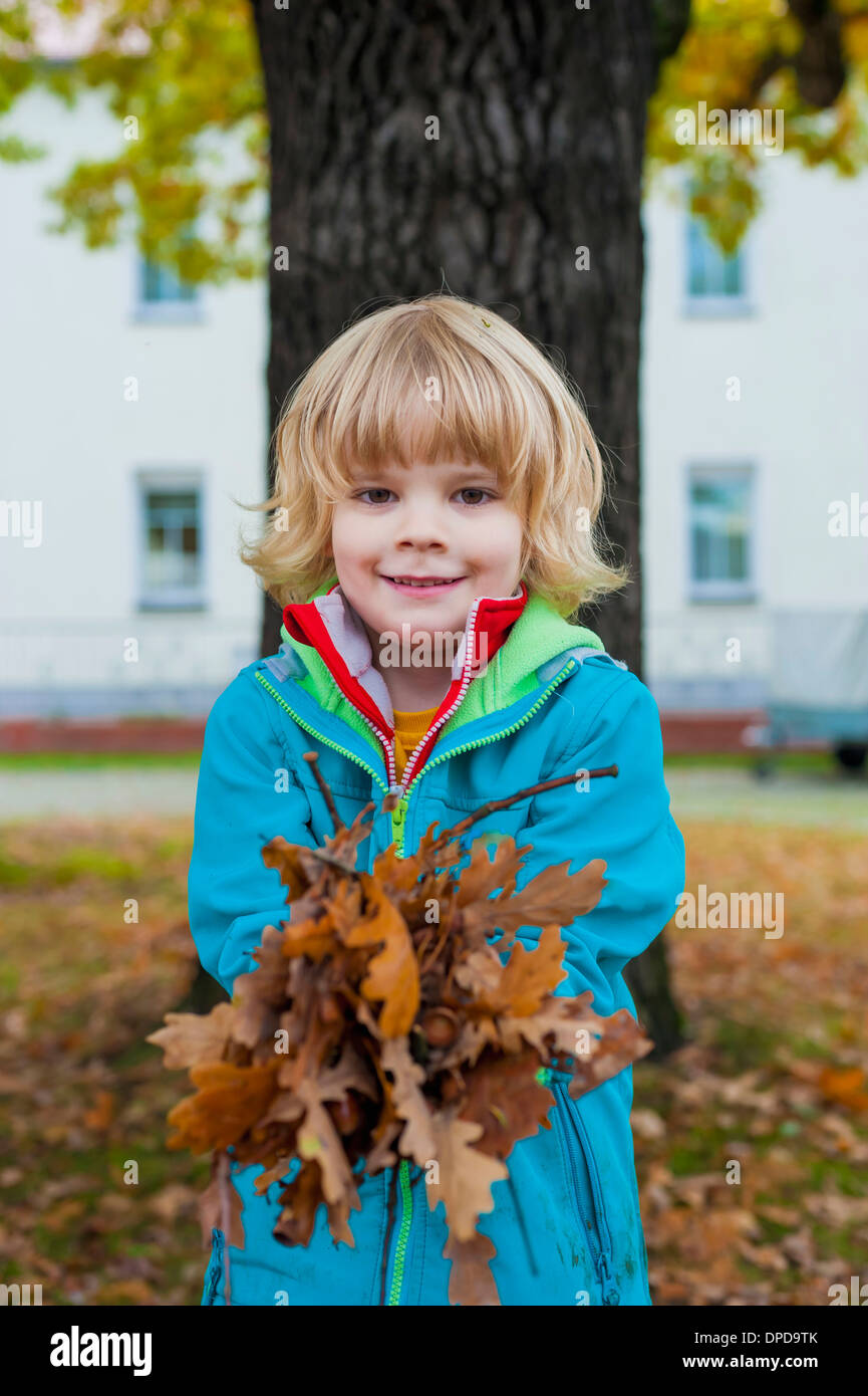 Little boy holding autumn leaves Stock Photo - Alamy