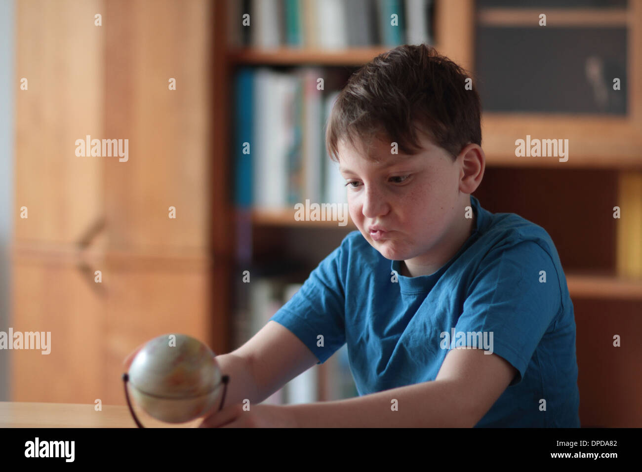 boy searching something on a world ball Stock Photo