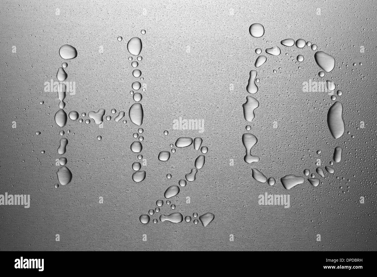 Water drops on metal sheet, forming H2O Stock Photo
