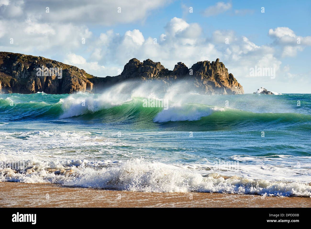A curling wave breaking at Porthcurno beach, West Cornwall Stock Photo