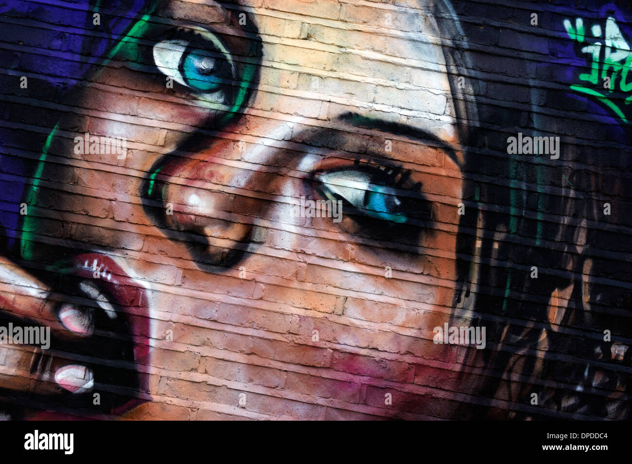 creative spray can wall portrait painting: urban graffiti Brick Lane area East London E1 UK Stock Photo