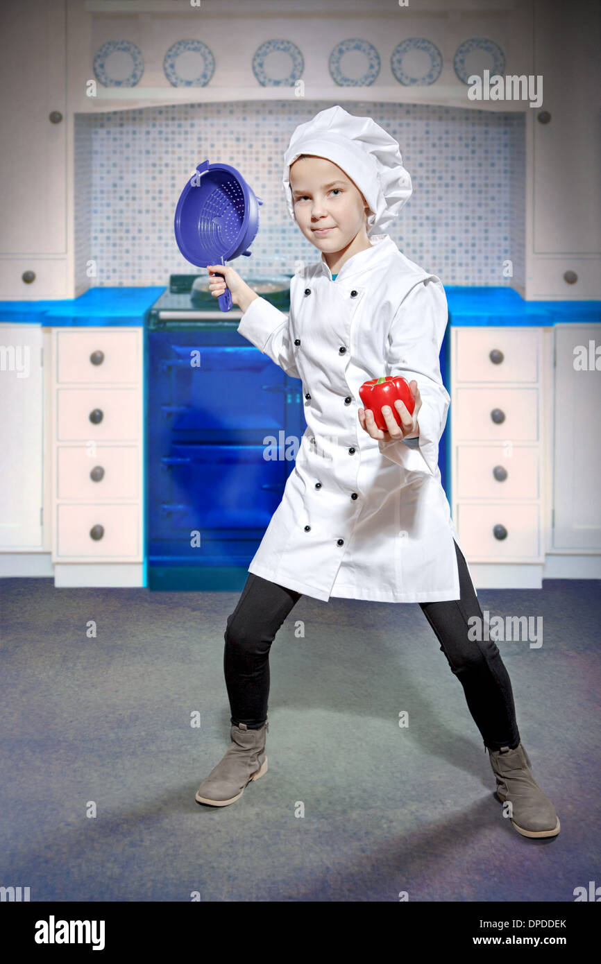 young female cook with a colander and paprika Stock Photo