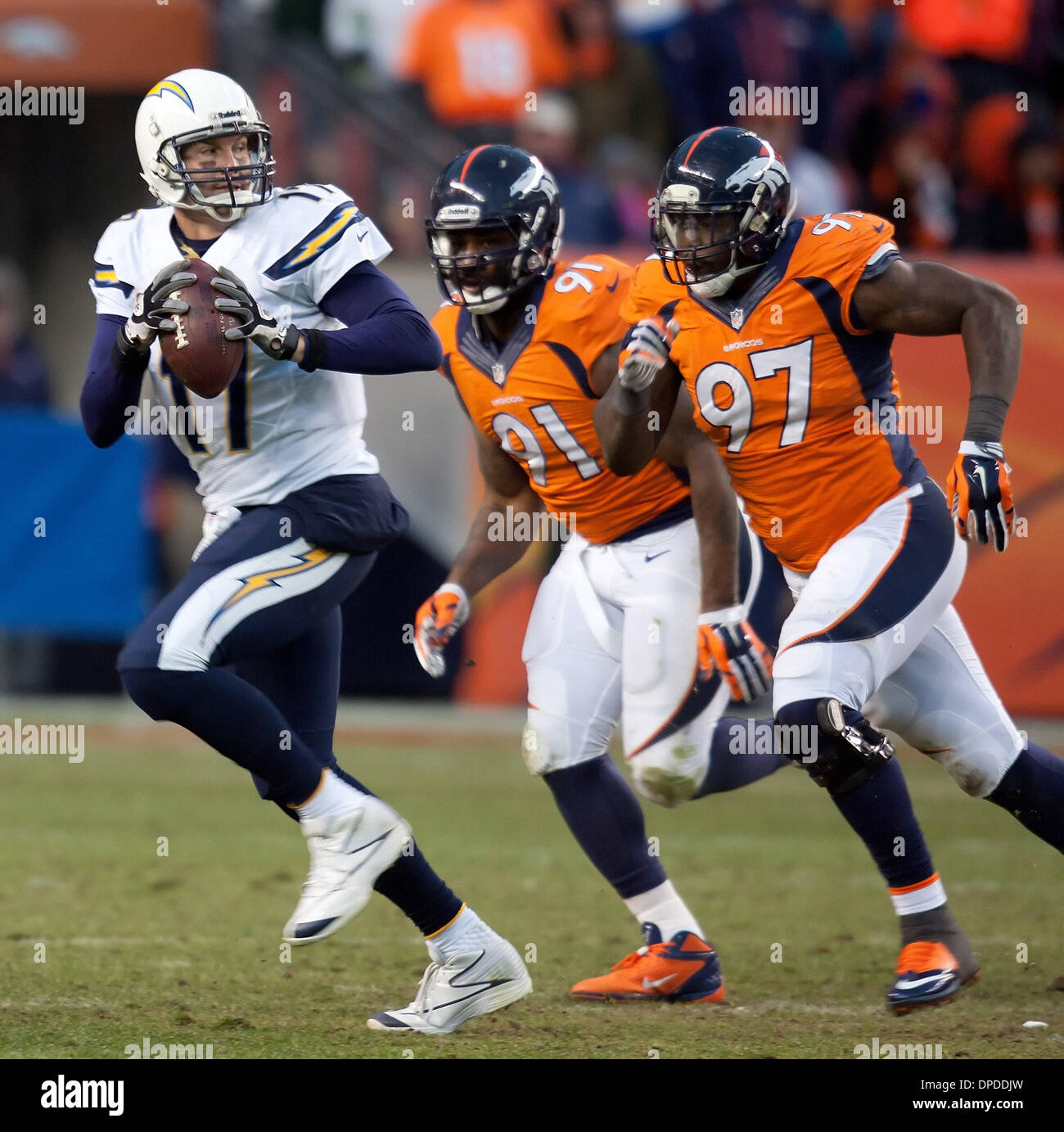 Jan. 12, 2014 - Denver, Colorado, U.S - Chargers QB PHILIP RIVERS, left, runs from Broncos pressure during the 2nd. half at Sports Authority Field at Mile High Sunday afternoon. The Broncos beat the Chargers 24-17. Stock Photo
