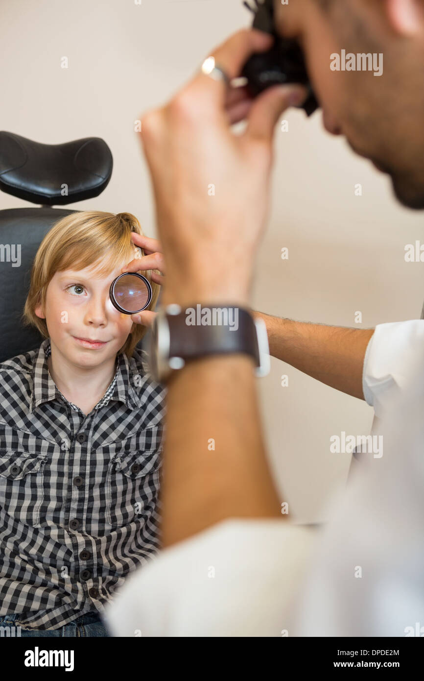 Boy Looking At Optician Examining His Eyes Through Lens Stock Photo