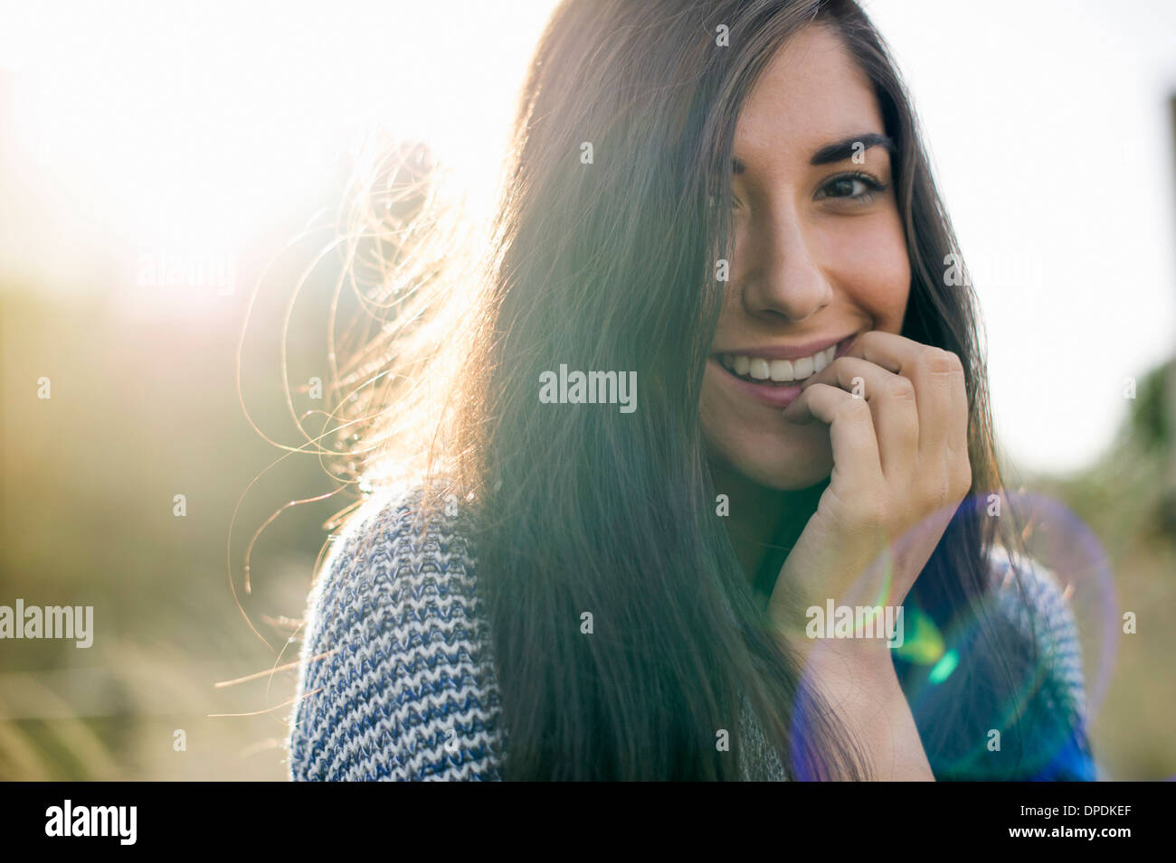 Portrait of young woman with long brown hair, smiling Stock Photo