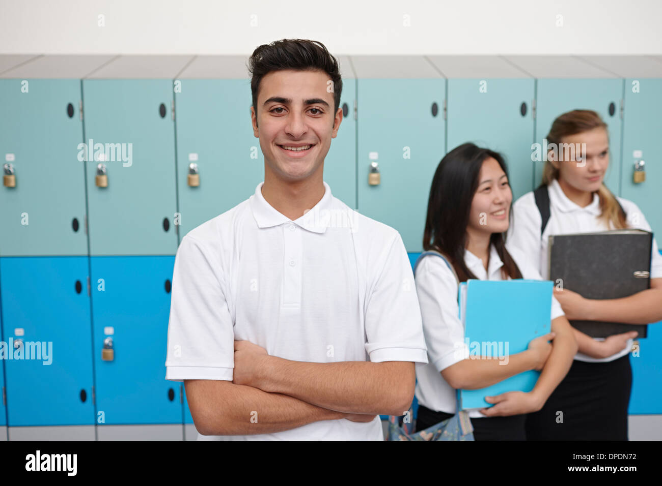 Portrait of teenage schoolboy next to lockers Stock Photo