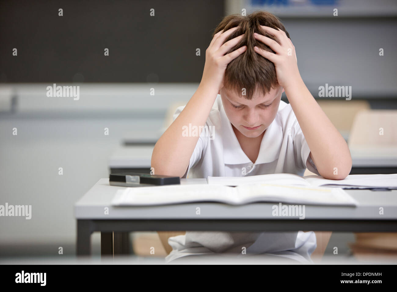 Schoolboy struggling in educational exam Stock Photo