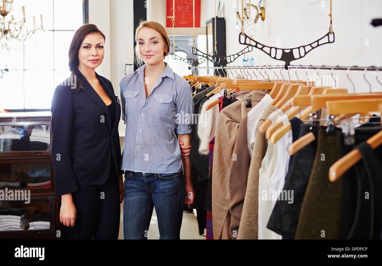 Young women standing in clothes shop Stock Photo - Alamy