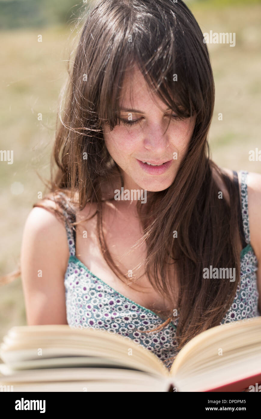 Mid adult woman reading book Stock Photo