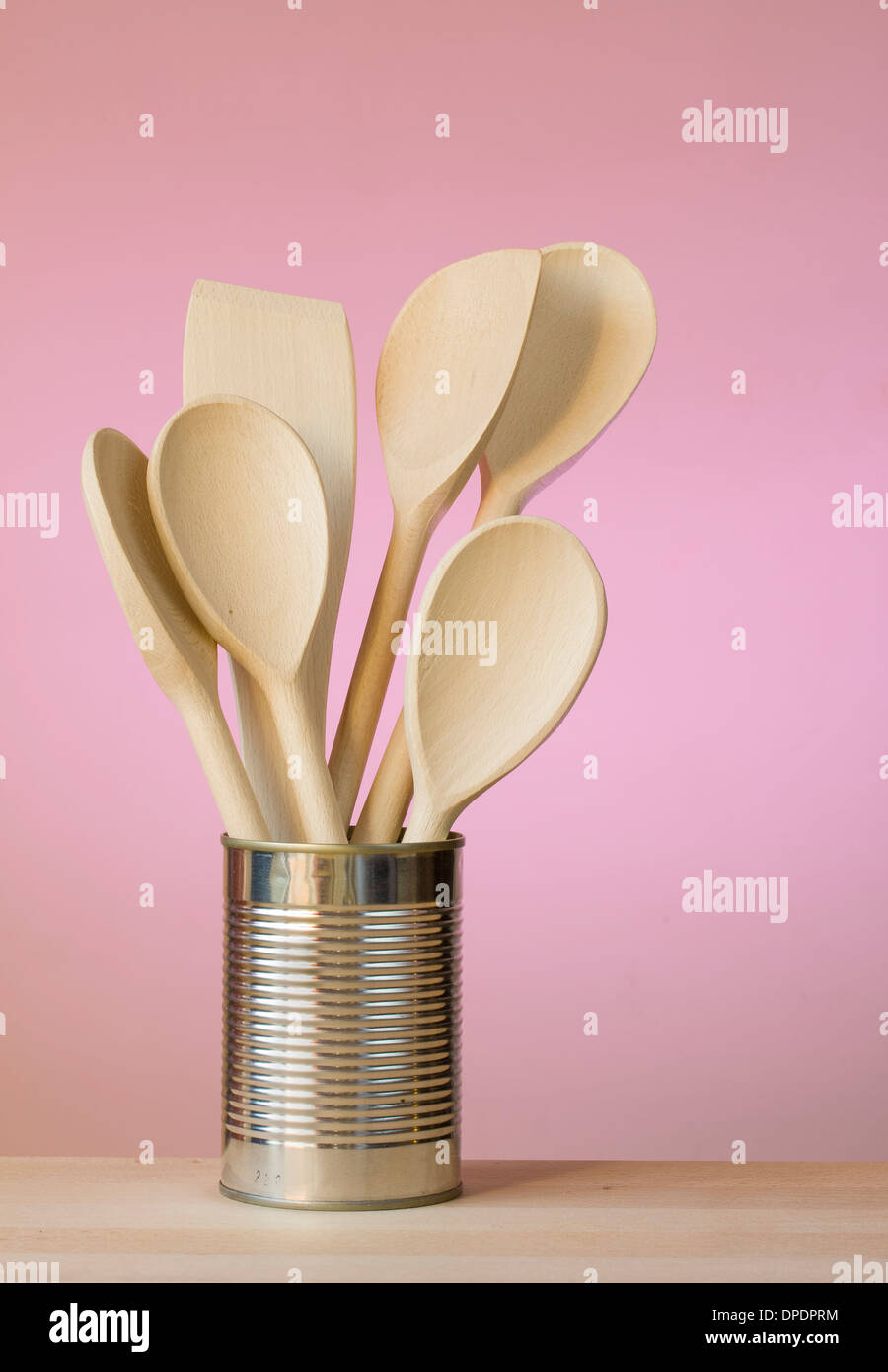 Kitchen utensils in a can with wall behind Stock Photo