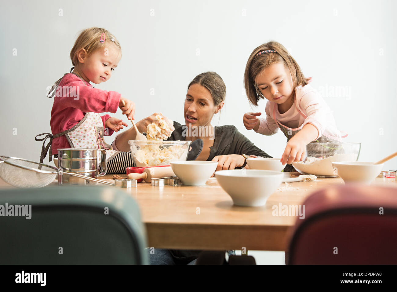 Mother and children baking, mixing batter Stock Photo