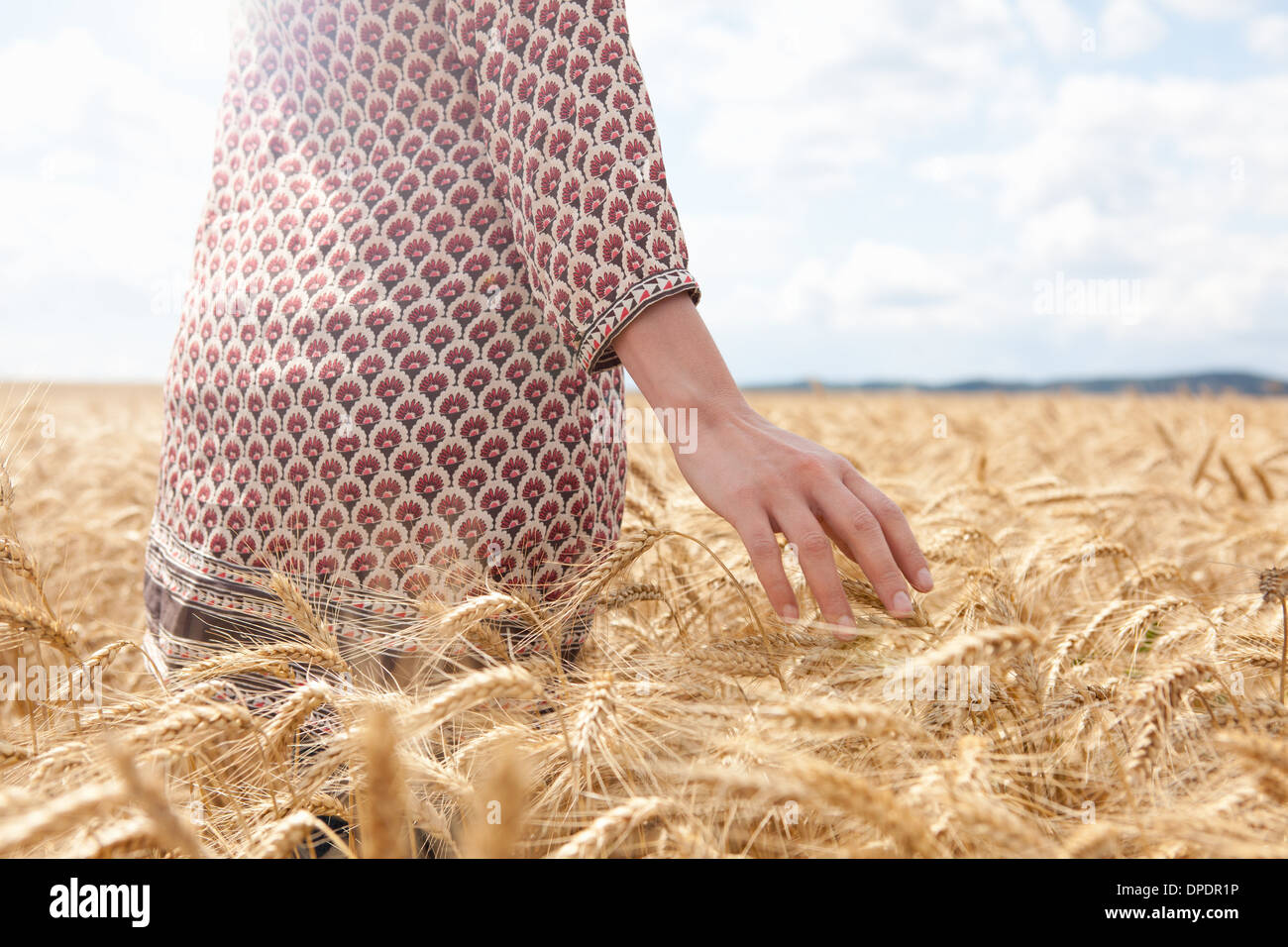 Mid section of woman in wheat field Stock Photo