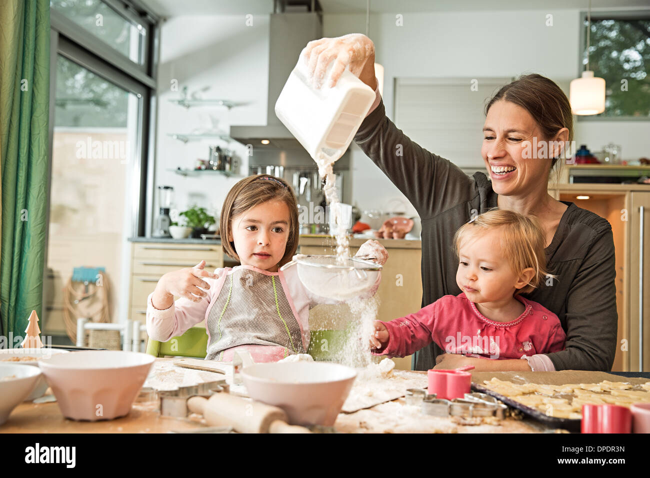 Mother and children baking in kitchen Stock Photo