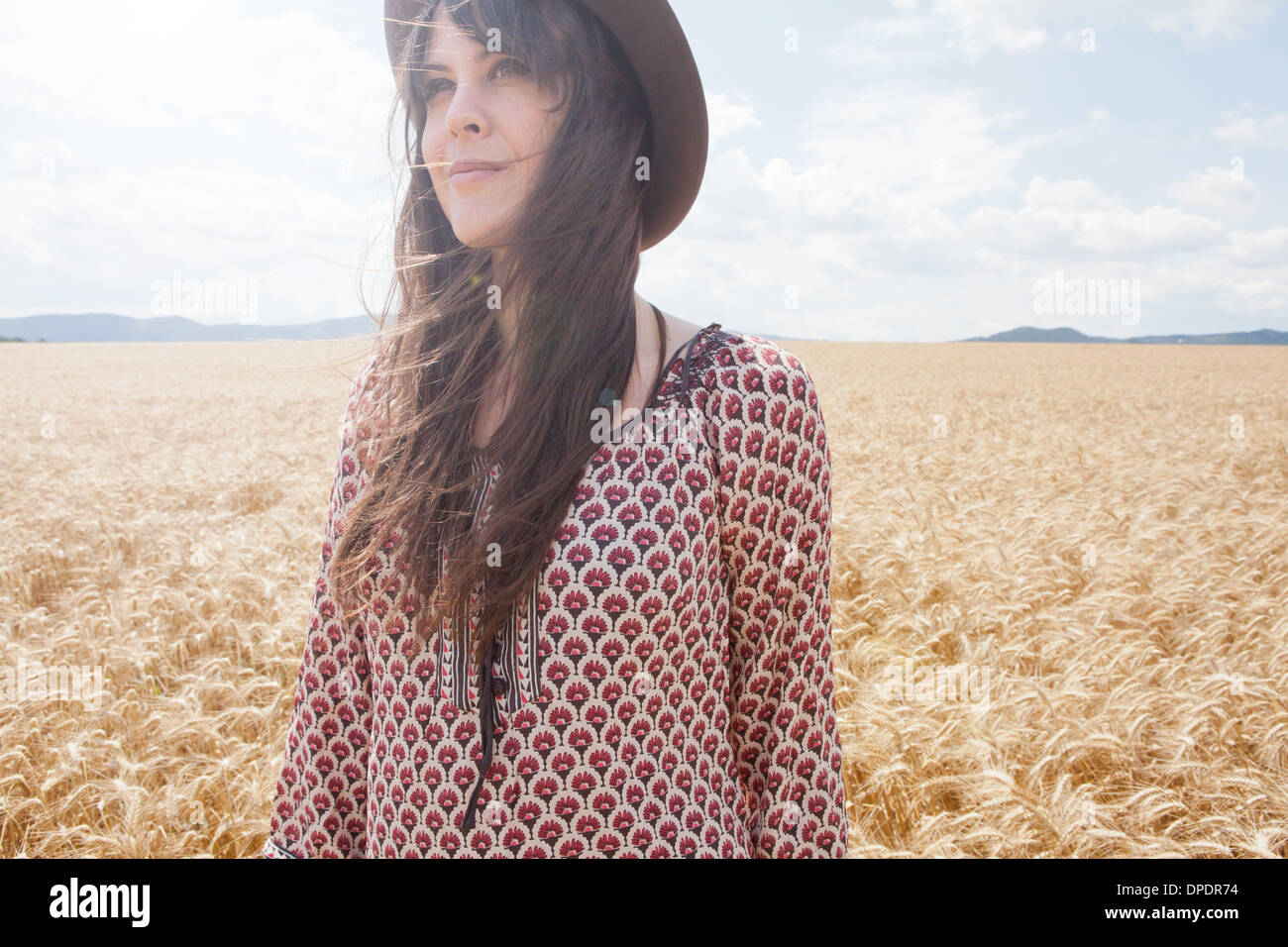 Mid adult woman standing in wheat field Stock Photo