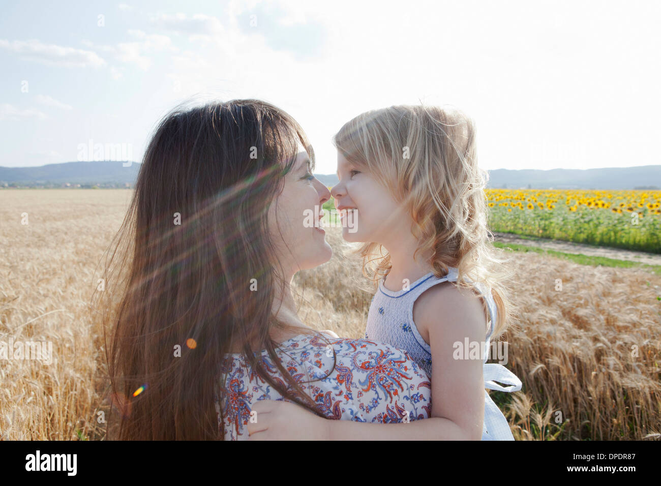 Mother and daughter in wheat field hugging Stock Photo