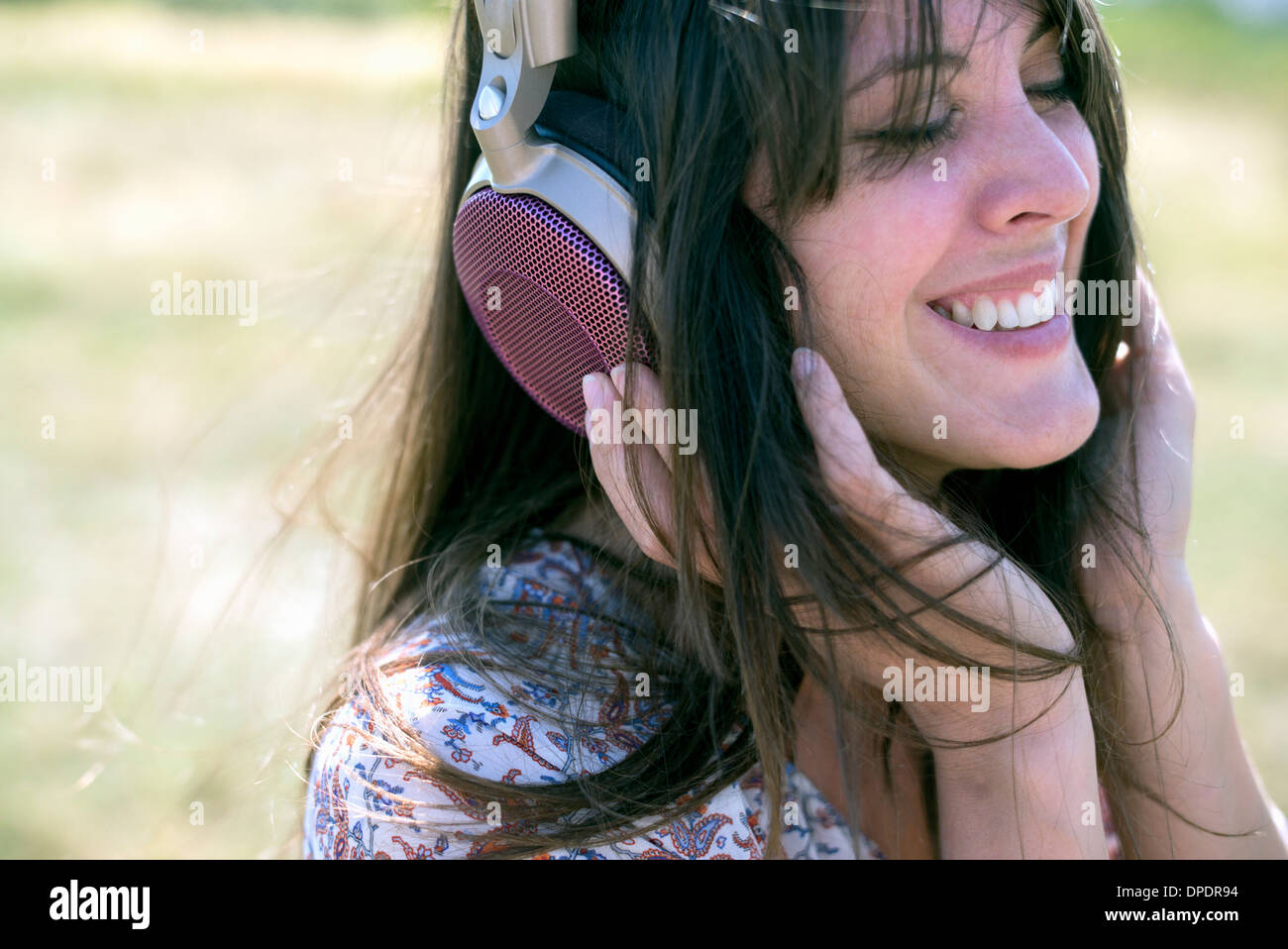 Mid adult woman wearing headphones with eyes closed Stock Photo