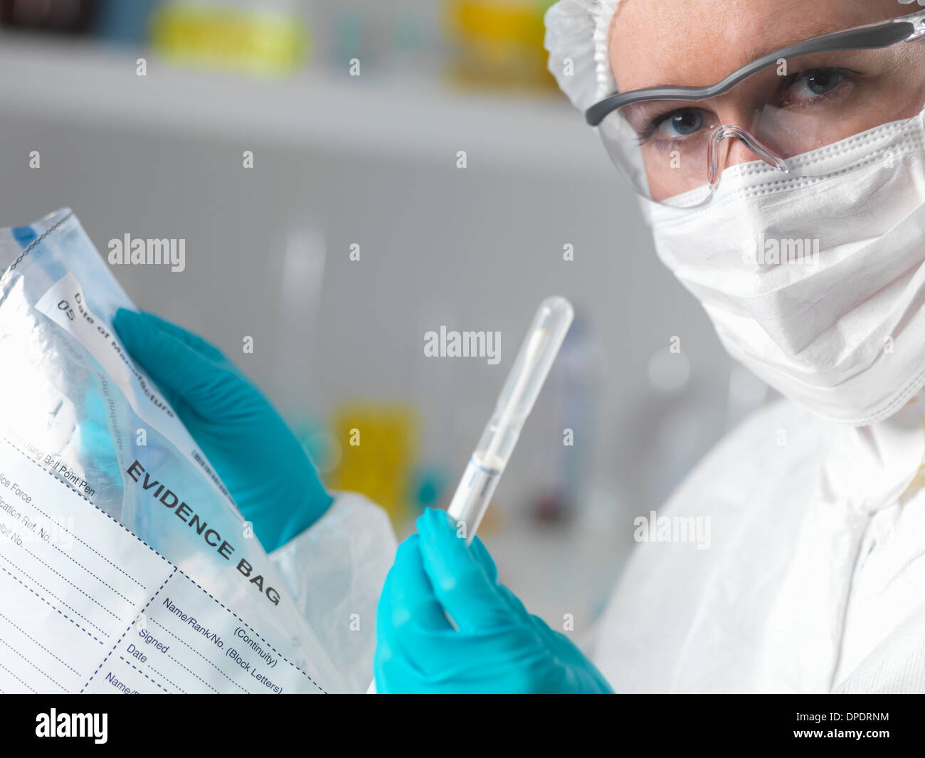 Forensic scientist in laboratory with evidence bag and swab for crime investigation Stock Photo