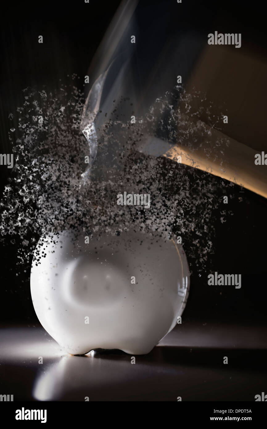 Close up hammer hitting piggy bank with blurred motion Stock Photo