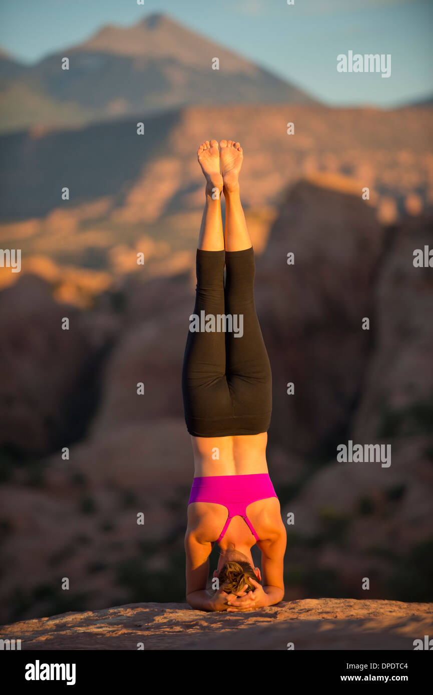 Young woman doing headstand, Moab, Utah, USA Stock Photo
