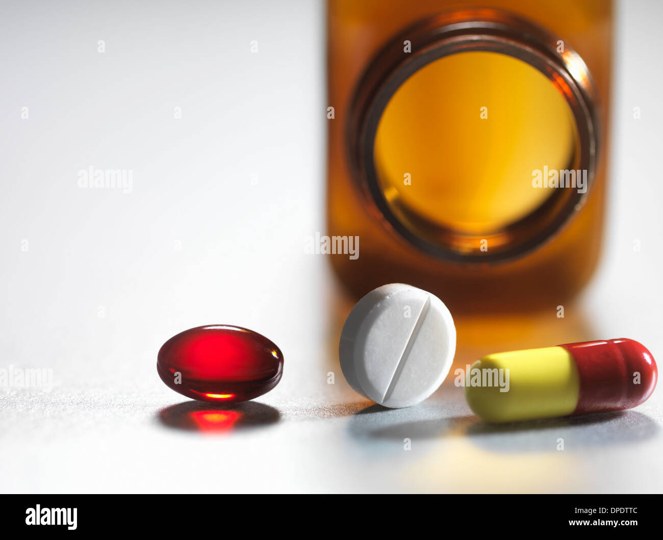 Pain killers pouring from brown medicine bottle Stock Photo