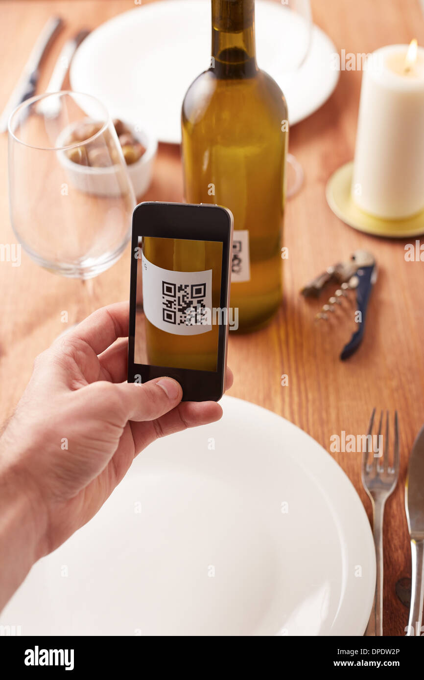 Smartphone taking photo of QR code on a wine bottle Stock Photo