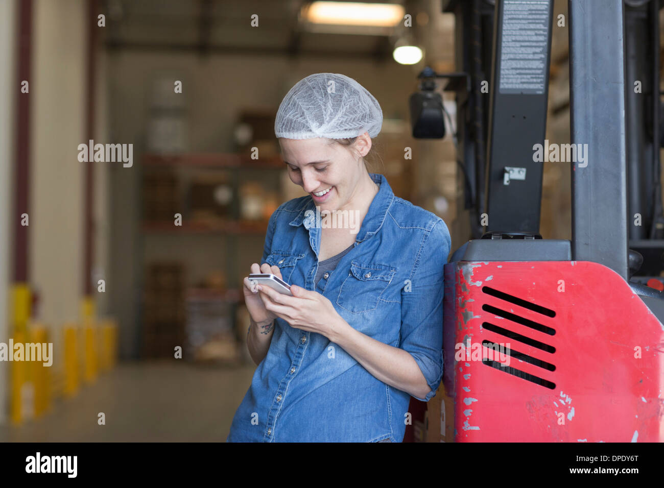 Portrait of female factory worker using cell phone Stock Photo - Alamy