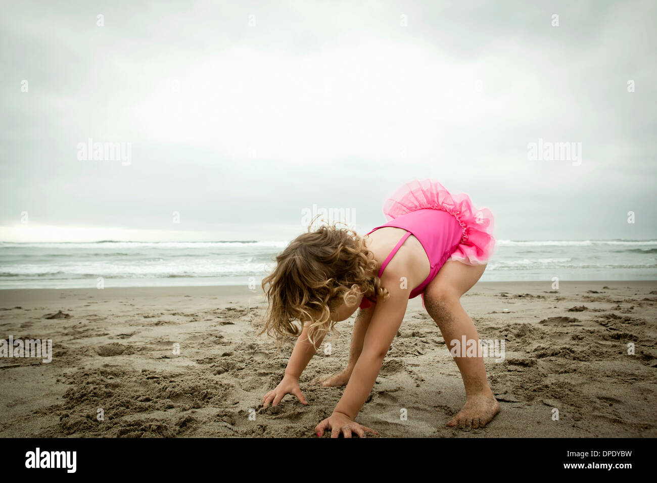 Female toddler playing with sand Stock Photo