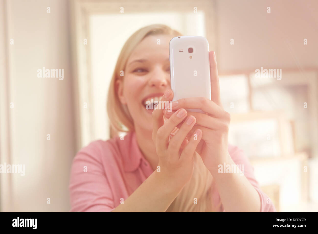 Young woman taking self portrait photograph using smartphone Stock Photo