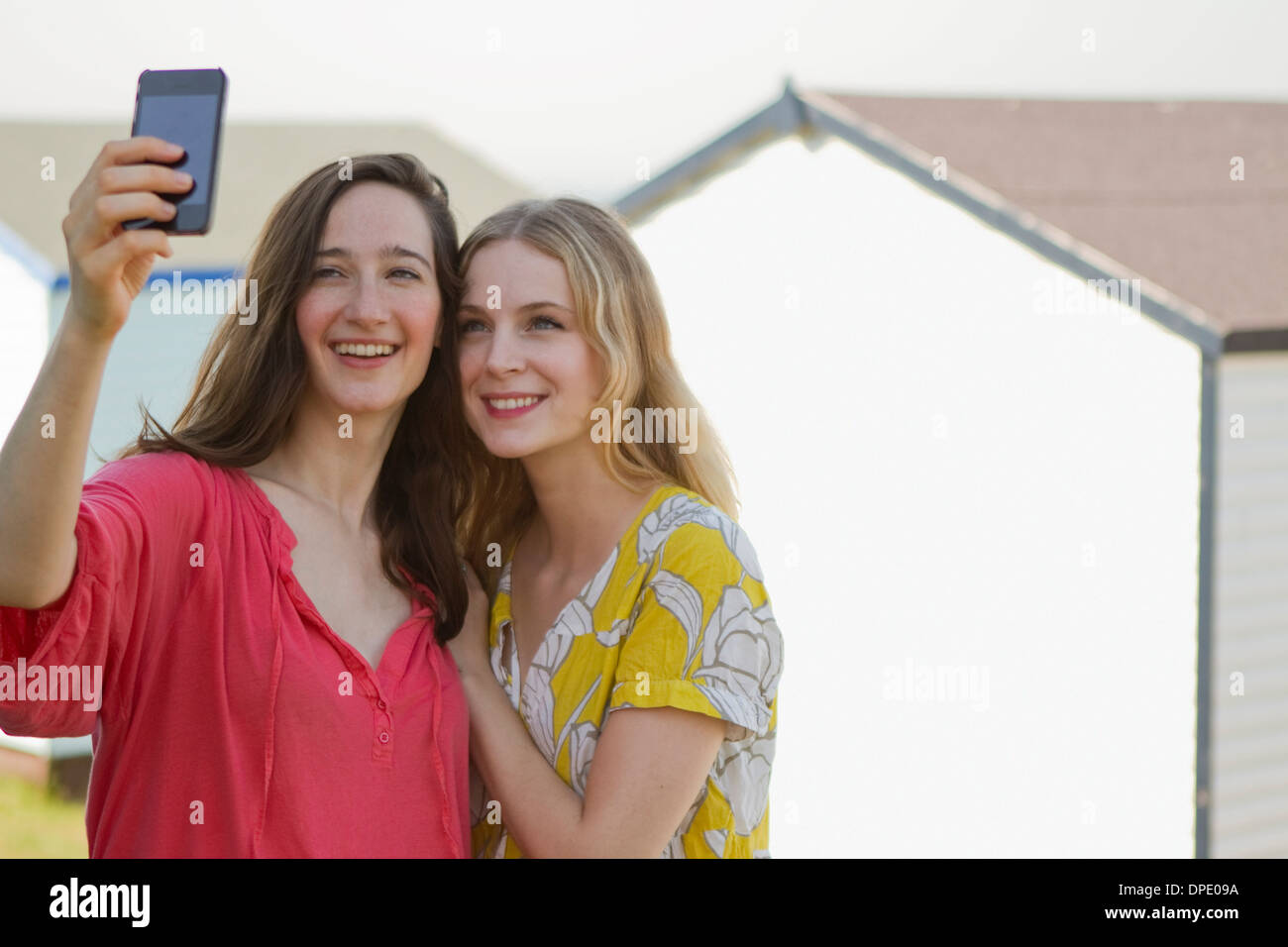 Two young female friends taking self portrait, Whitstable, Kent, UK Stock Photo