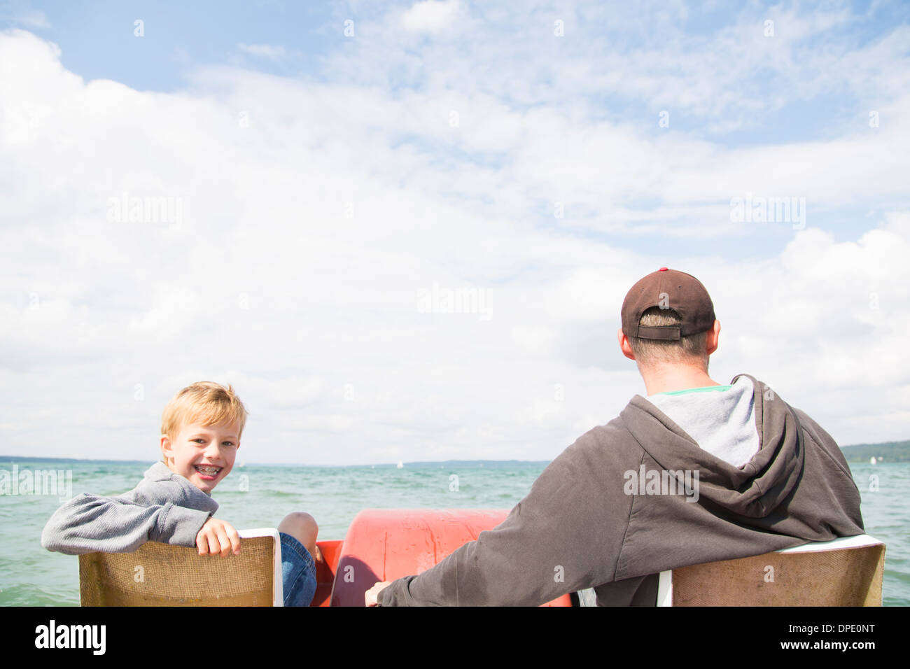 Father and son on pedalo, Lake Ammersee, Bavaria, Germany Stock Photo